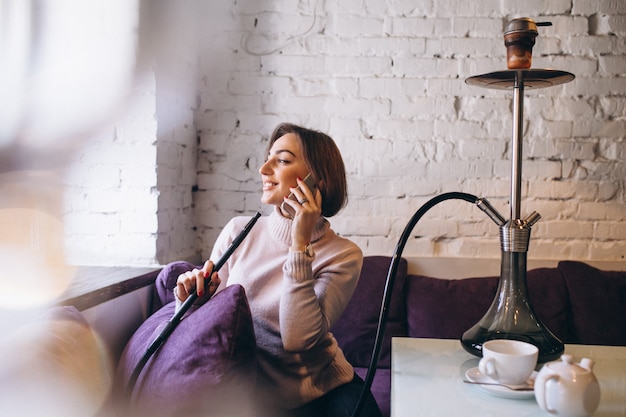 Vrouw met telefoon en shisha