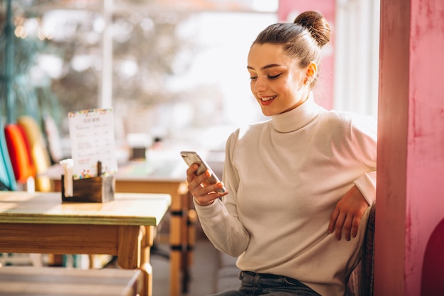 Vrouw met telefoon in een café