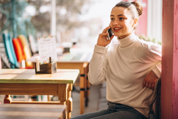 Vrouw met telefoon in een café