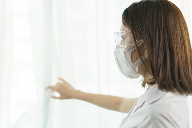 Vrouw met veiligheidsbril en masker, om de verspreiding van coronavirus te voorkomen.