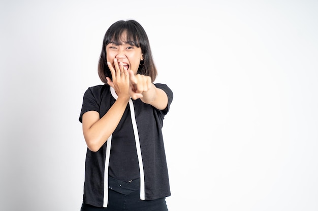 Vrouw met vinger wijzend naar frong en lachen om iets