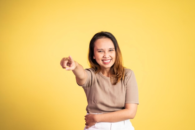 Vrouw met vinger wijzend naar frong en lachen om iets