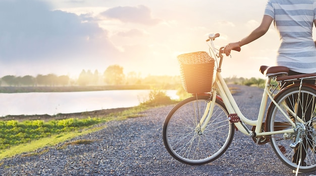 vrouw met vintage fiets, ontspannen in de natuur landelijke zomer zonsondergang