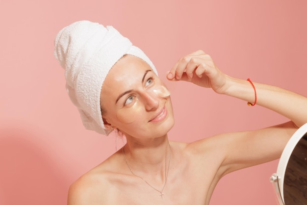 Vrouw met vlekken onder haar ogen die haar gladde huid aanraken