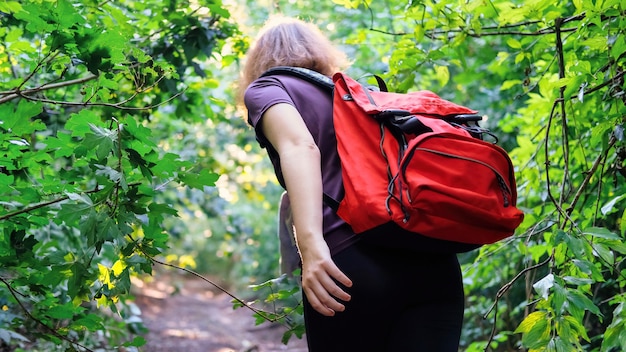 Vrouw met wandelrugzak op een parcours in een bos