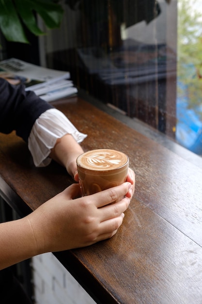 Vrouw met warme kop latte koffie