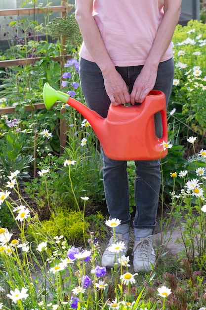 Foto vrouw met waterring kan in de tuin
