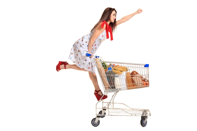 Vrouw met winkelwagen vol met producten geïsoleerd op witte achtergrond