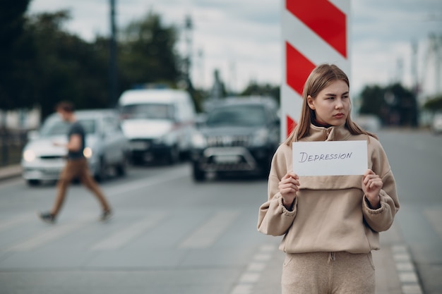 Vrouw met wit vel papier met het label woord Depressie in de hand.