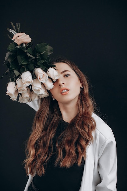 Vrouw met witte rozen op zwarte achtergrond