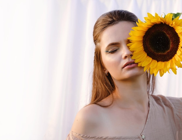 Vrouw met zonnebloem over gezicht