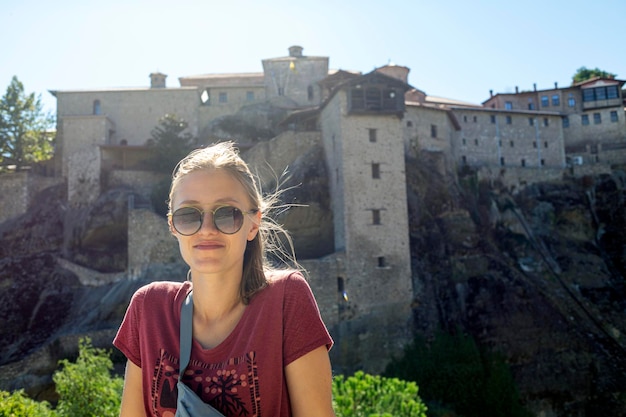 Foto vrouw met zonnebril verkent historisch grieks klooster te midden van verbluffende architectuur en mooie uitzichten