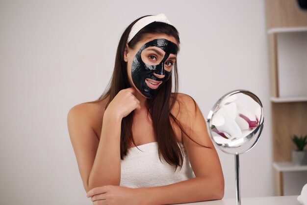 Vrouw met zuiverend afpelbaar zwart masker