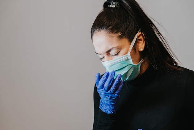 Foto vrouw met zwart haar die handschoenen en het hoesten dragen