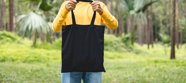 Vrouw met zwarte katoenen tas in de natuur achtergrond