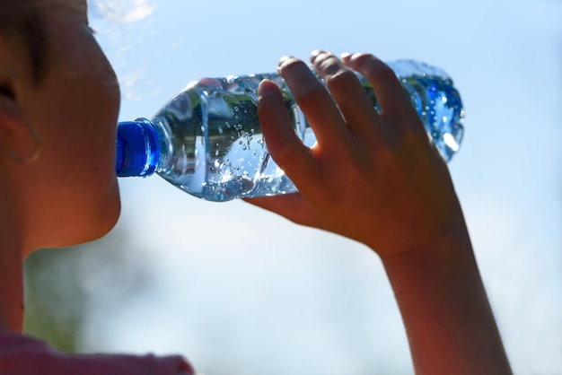 Vrouw mineraalwater drinken en rusten tijdens het joggen in het park