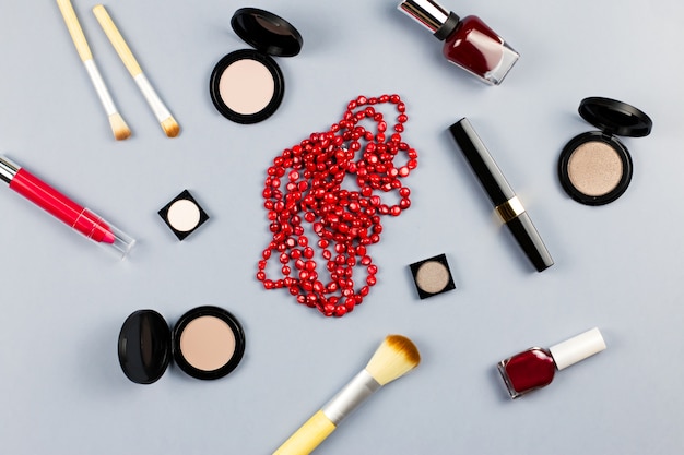 Vrouw mode accessoires, sieraden en cosmetica op stijlvolle grijze achtergrond. Plat leggen