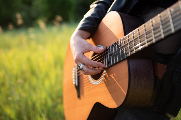 Vrouw muzikant akoestische gitaar spelen in de natuur