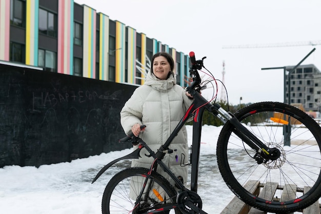 Vrouw naast fiets in de sneeuw