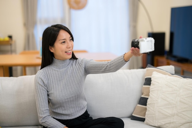 Vrouw neemt beelden op camera thuis.