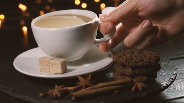 Vrouw neemt een kopje koffie en drinkt concept kerstcafé gekruide koffie