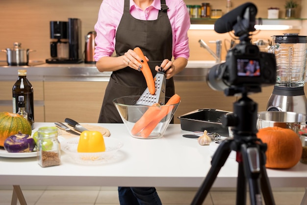 Vrouw neemt video op van haar kookkunsten voor online videoblog