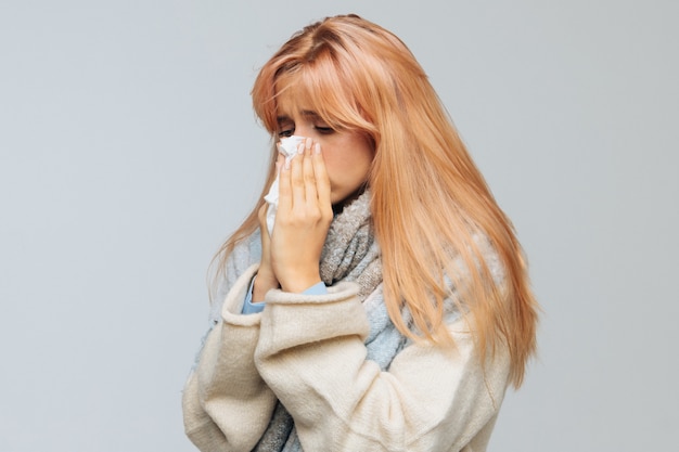 Vrouw niezen, met behulp van servet. Rhinitis, allergie, griep