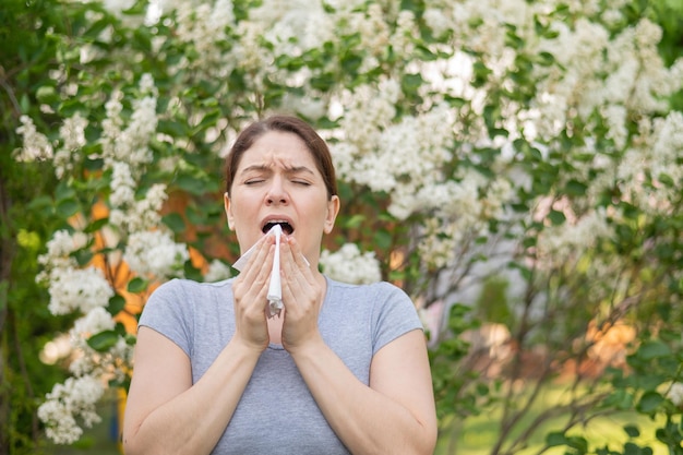 Foto vrouw niezen tegen bloem boom