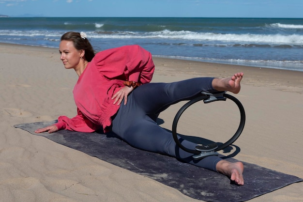 Vrouw oefenen op het strand met pilates ring