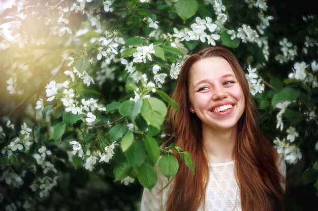 Vrouw onder de Lentebloemen in de natuur