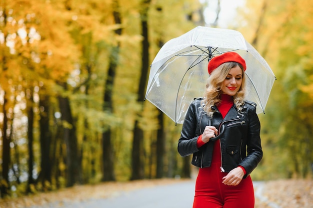 Vrouw onder paraplu loopt in het park in de herfst