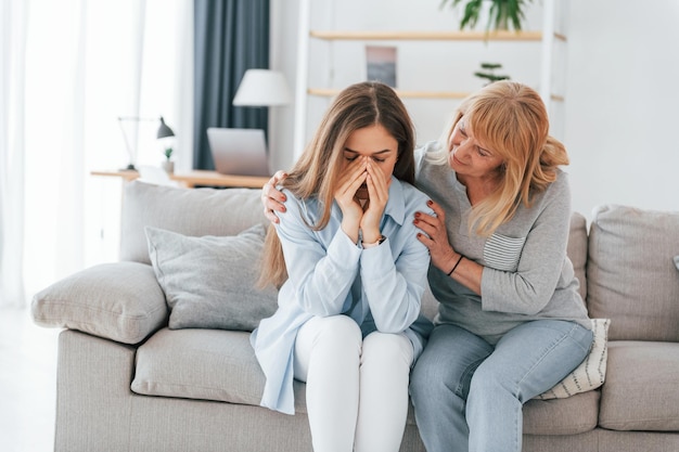 Vrouw ondersteunt haar dochter Moeder en vrouw zijn samen thuis