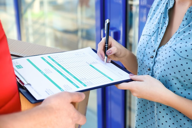 Vrouw ondertekening voor pakketbezorging close-up