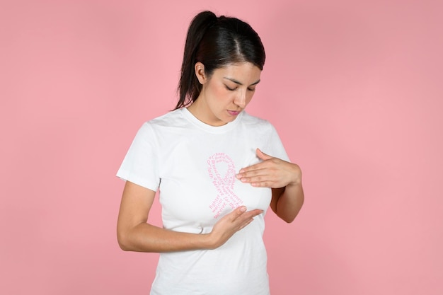 Vrouw onderzoekt haar borsten in een roze lint shirt concept van het bestrijden van borstkanker