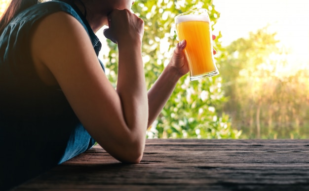 Vrouw ontspannen door een glas bier op het balkon in de zomer