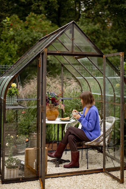 Vrouw ontspannen in kas in tuin