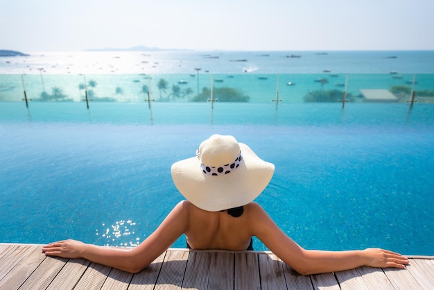 Vrouw ontspant in een infinity pool tegen de zee
