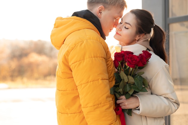 Vrouw ontvangt een boeket rode rozen van vriendje op Valentijnsdag terwijl ze buiten is
