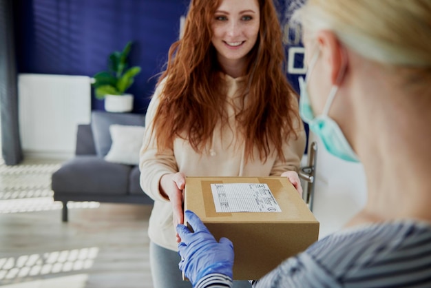 Foto vrouw ontvangt een pakketje van een bezorger