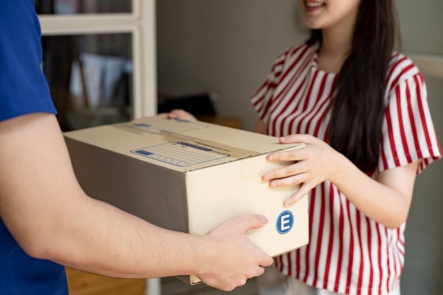 Vrouw ontvangt voor het huis een pakket van een expresbezorger.