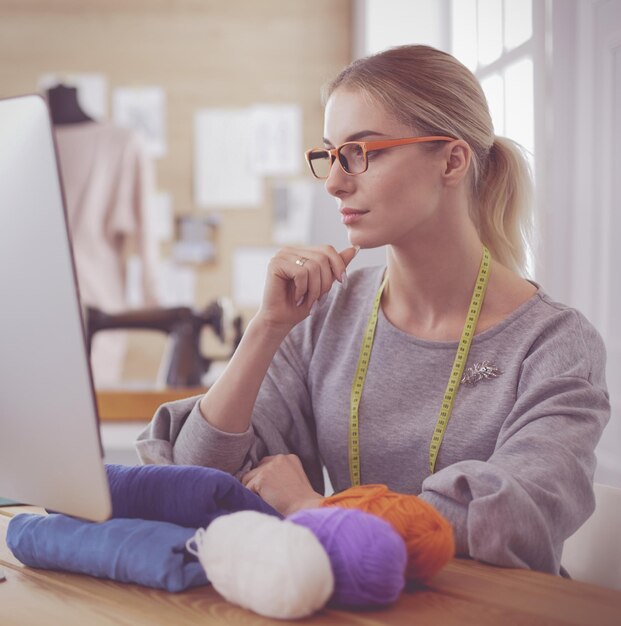 Vrouw ontwerper in werkplaats kijken naar computerscherm