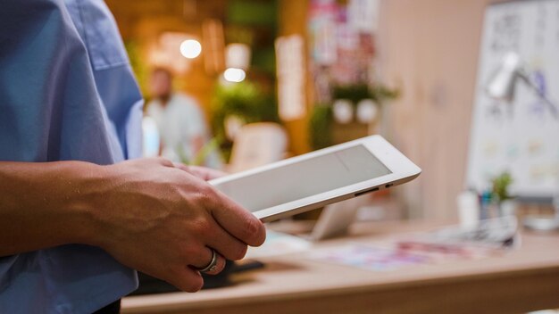 Vrouw ontwerper met een digitale tablet-pc in handen, close-up shot. Loftkantoor op de achtergrond