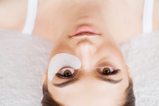 Vrouw oog met lange wimpers. Mooie jonge vrouw tijdens wimper extensie