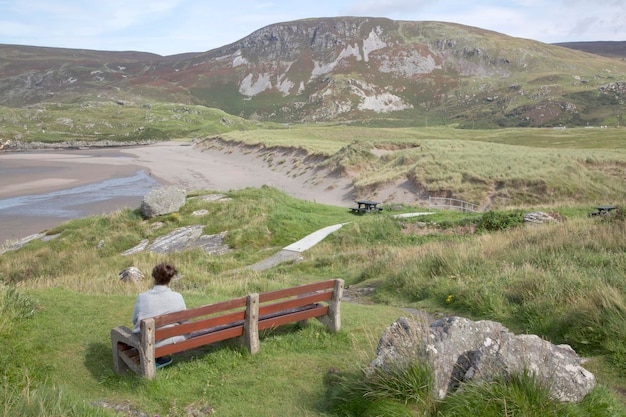 Vrouw op Bank bij Glencolumbkille Beach, Donegal, Ierland