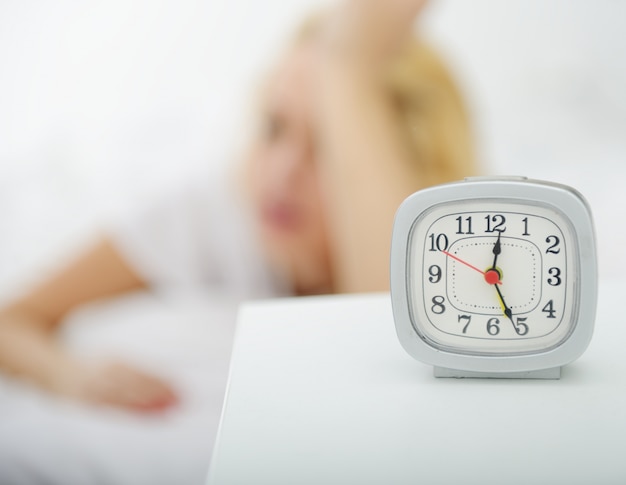 Vrouw op bed in de slaapkamer met horloge