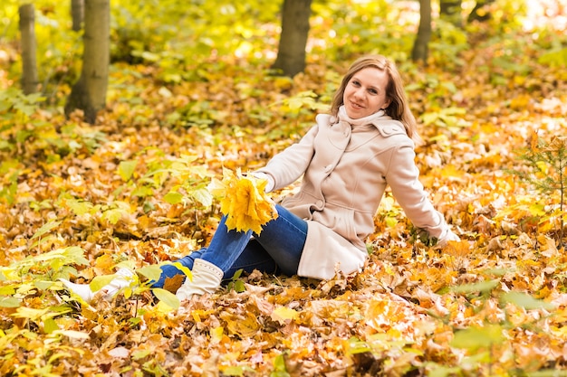 vrouw op bladeren in herfst park