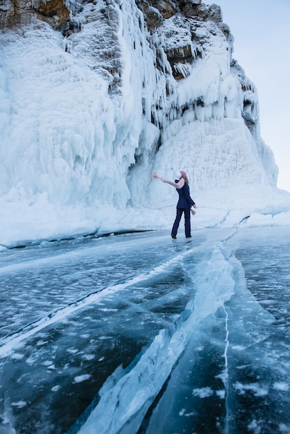 Vrouw op de achtergrond van ijzige rotsen en bevroren Baikalmeer