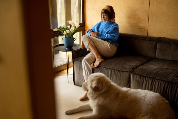 Vrouw op de bank in een houten huis op de natuur