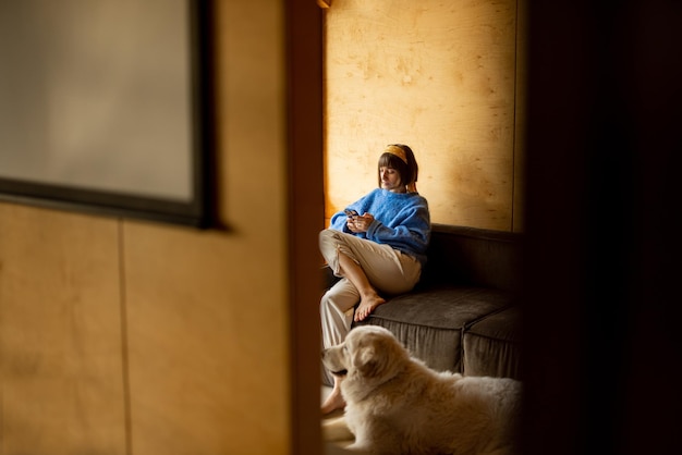 Vrouw op de bank in een houten huis op de natuur