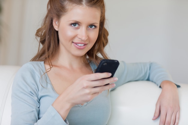 Vrouw op de laag die op haar smartphone typen